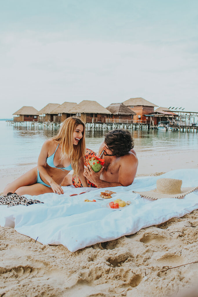 A man and woman sitting on the beach