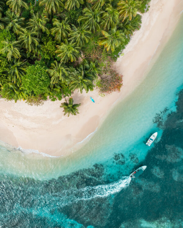 A boat is sailing on the water near an island.